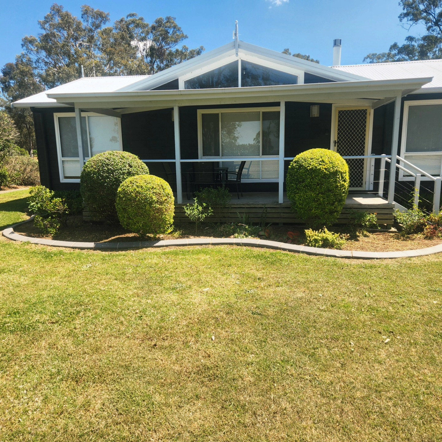 Sphere topiary beside farmhouse verandah — Hills District acreage
