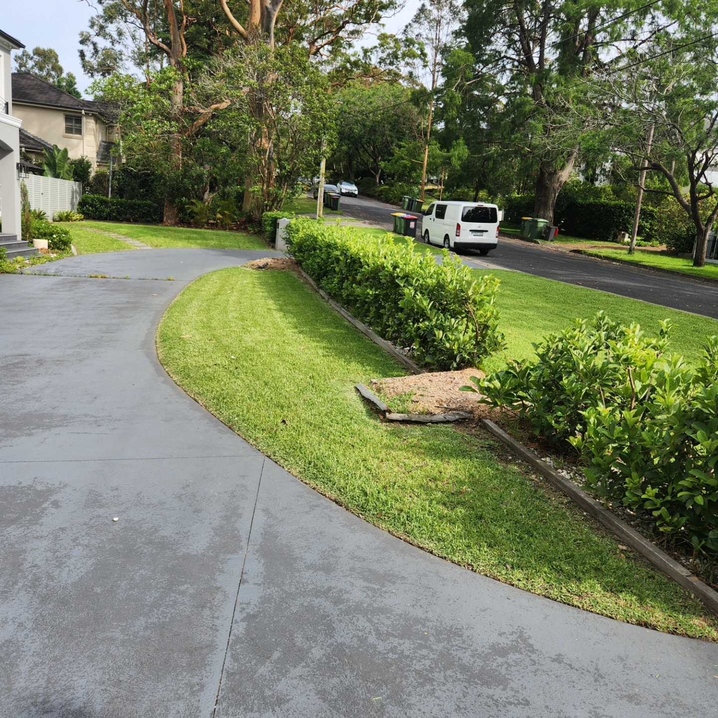 Clean curved driveway with manicured lawn — North Shore
